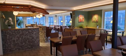 a restaurant with tables and chairs and windows at Hotel zum Kreuzberg in Winterberg