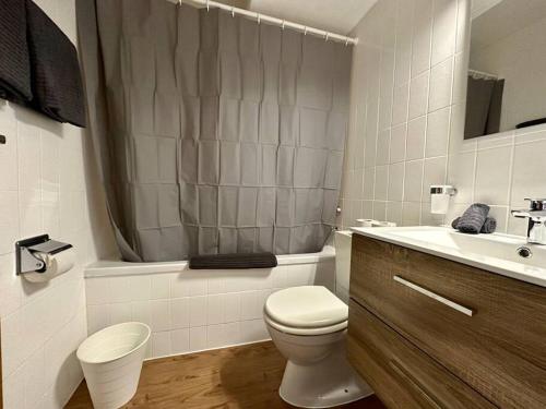 a white bathroom with a toilet and a sink at Alpine Retreat: 4-Person Apartment near Zermatt in Täsch