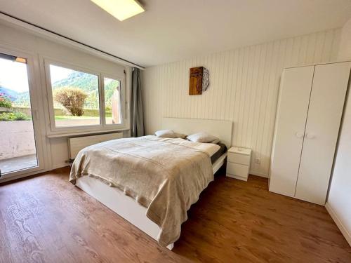 a bedroom with a bed and a large window at Alpine Retreat: 4-Person Apartment near Zermatt in Täsch