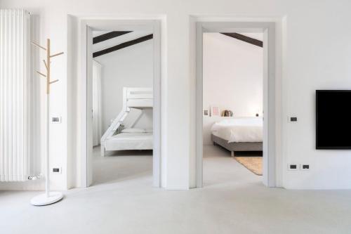 a white bedroom with a bed and a tv at Charming loft in Venetian Villa in Noale