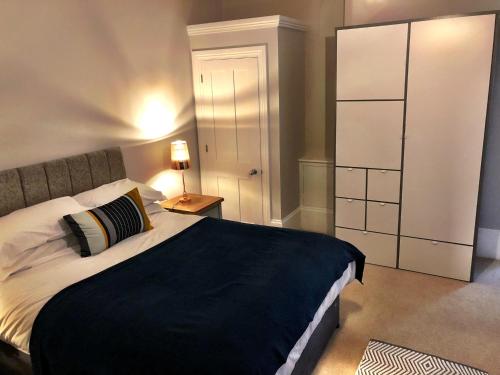 a bedroom with a large bed and a white closet at A spacious 1 bedroom in an historic building in Newbury