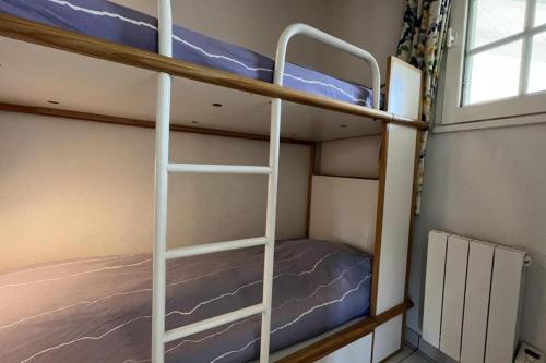deux lits superposés dans une chambre avec fenêtre dans l'établissement Appartement La Rotonde à Port Bourgenay, à Talmont-Saint-Hilaire