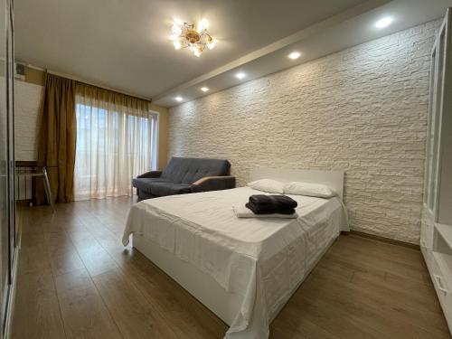 a bedroom with a bed and a chair in it at Квартира с гостиничным сервисом бизнес-класса с большой ванной и Smart-TV in Petropavlovsk