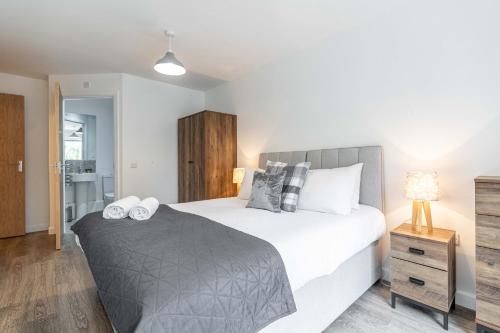 a bedroom with a large bed and a bathroom at Cotels at Centro Serviced Apartments in Northampton
