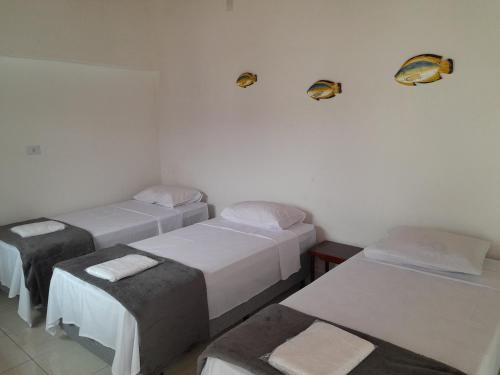 a room with three beds and two seats at Recanto do Centro in Cananéia