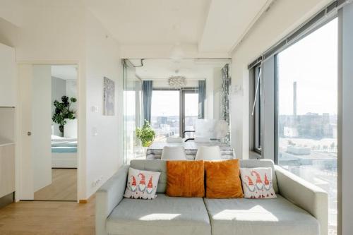 a living room with a couch with orange pillows at Fabulous Morden Apartment in Helsinki in Helsinki