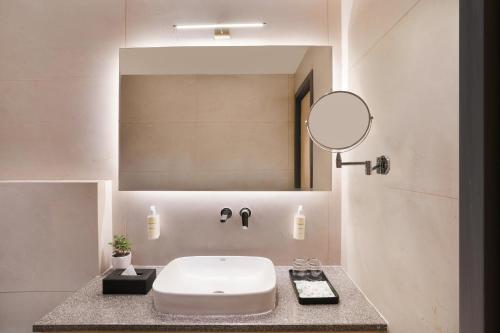 a bathroom with a white sink and a mirror at Lemon Tree Hotel, Haridwar in Haridwār