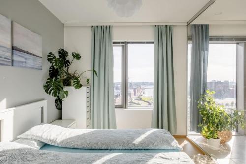 Fabulous Morden Apartment in Helsinki في هلسنكي: غرفة نوم بسرير ونوافذ كبيرة