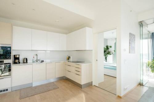 a kitchen with white cabinets and a large window at Fabulous Morden Apartment in Helsinki in Helsinki