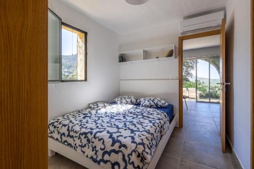 une chambre avec un lit avec une couette bleue et blanche dans l'établissement Belle Vue de Fogata, à Corbara