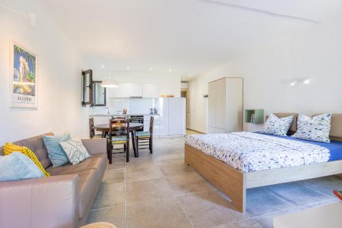 ein Schlafzimmer mit einem Bett und einem Sofa sowie eine Küche in der Unterkunft Petite Pause de Fogata - Jolie vue mer in Corbara