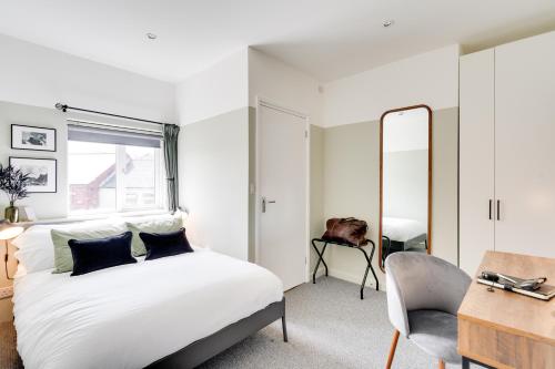 1 dormitorio con cama, silla y espejo en Urban Oasis by Keystone en Newport
