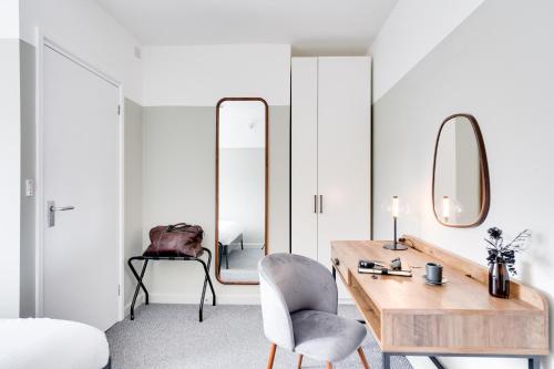 1 dormitorio con escritorio, silla y espejo en Urban Oasis by Keystone en Newport