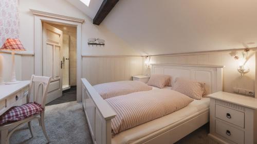 a bedroom with two beds and a desk and a sink at Aparthotel Ansitz Felsenheim in Lermoos