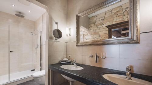 a bathroom with a sink and a toilet and a mirror at Aparthotel Ansitz Felsenheim in Lermoos