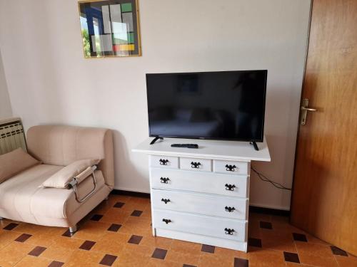 ein Wohnzimmer mit einem TV und einer Kommode in der Unterkunft Residenza Marisa in Sirmione