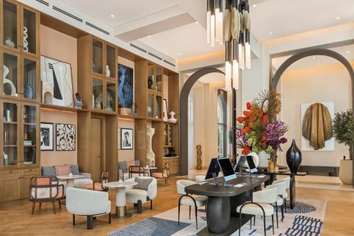 a lobby with chairs and tables and a chandelier at Vida Creek Beach Hotel in Dubai
