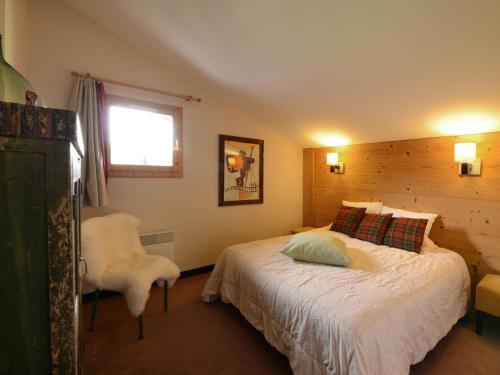 une chambre avec un lit, une chaise et une fenêtre dans l'établissement Appartement rénové 4 pièces, accès direct aux pistes, 8 pers. - FR-1-181-2032, à La Plagne Tarentaise
