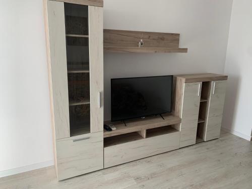 a wooden entertainment center with a flat screen tv at Residence Tineretului in Roşu