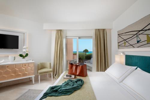 ein Hotelzimmer mit einem Bett und einem Bad in der Unterkunft Hotel Abi d'Oru in Porto Rotondo