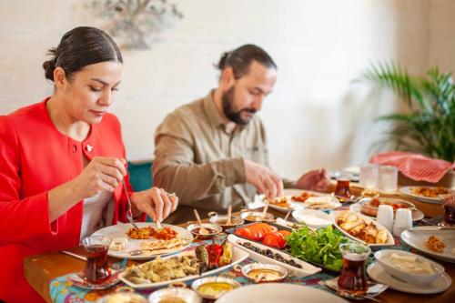 un gruppo di persone sedute a un tavolo che mangiano cibo di ASTARTE HOTEL a Şanlıurfa