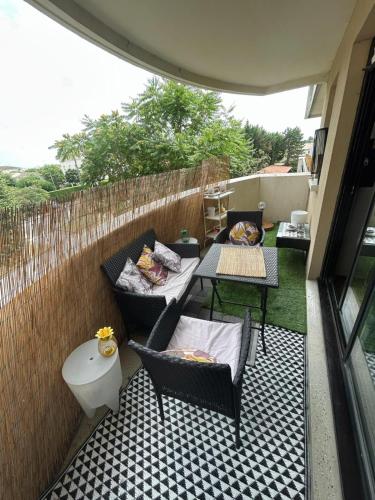 eine Terrasse mit einem Tisch, Stühlen und einem WC in der Unterkunft Appartement agréable 1 chambre in Mérignac