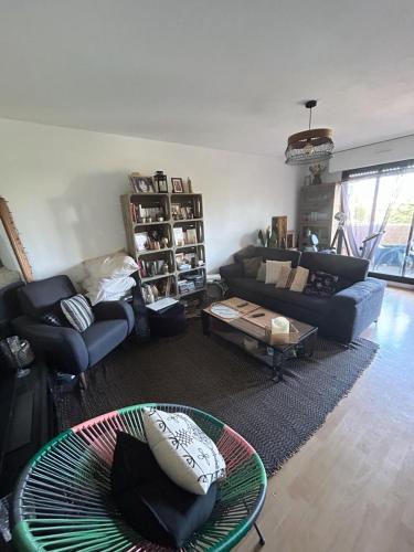 un salon avec un canapé et une table dans l'établissement Appartement agréable 1 chambre, à Mérignac