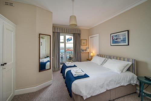 a bedroom with a large white bed and a window at Royal London Yacht Club in West Cowes