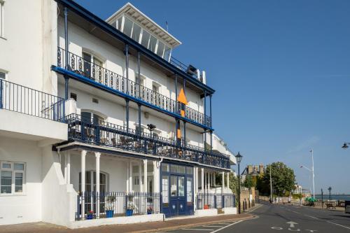 a white building with blue balconies on a street at Royal London Yacht Club in West Cowes