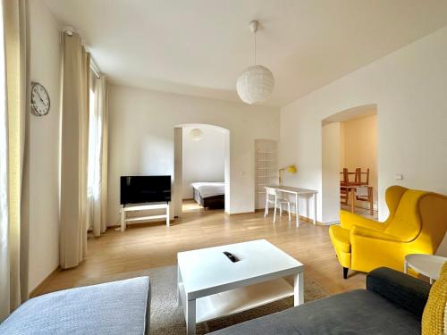 a living room with a yellow couch and a table at Residence Caesar by Homester in Brno