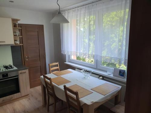 a kitchen with a table with chairs and a window at Veľký Apartmán 2-4 osôb v srdci Tatier in Liptovský Hrádok