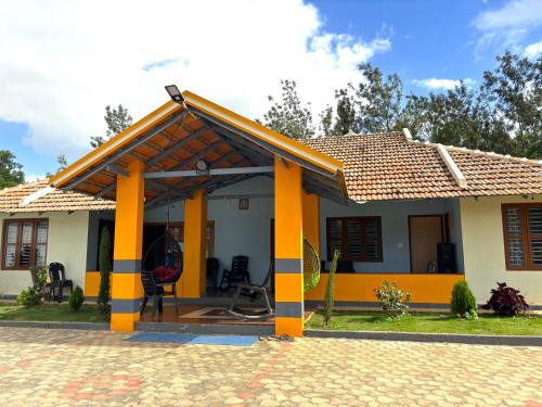 ein kleines Haus mit Orange und Weiß in der Unterkunft STAYMAKER Siri Vismaya Home Stay in Chikmagalur