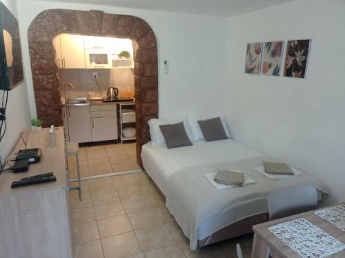 ein kleines Schlafzimmer mit einem Bett und einer Küche in der Unterkunft Apartman Dardic in Herceg-Novi