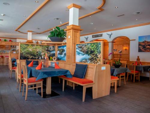 ein Restaurant mit Holztischen und Stühlen mit blauen Sitzgelegenheiten in der Unterkunft Landal Hochmontafon in Gargellen