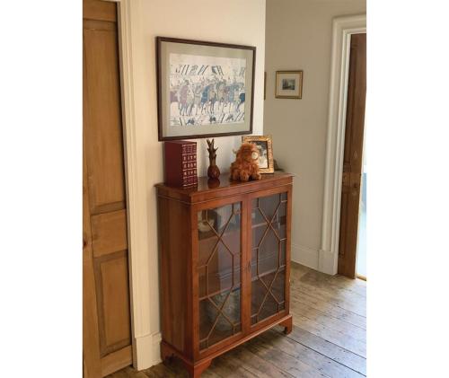 a cat sitting on top of a wooden cabinet in a room at Edradour in St. Andrews