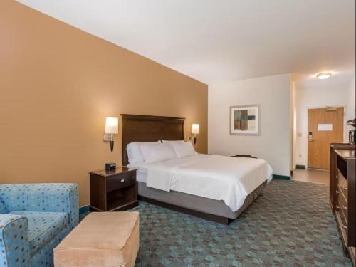 een grote hotelkamer met een bed en een stoel bij Holiday Inn Express & Suites - Canton, an IHG Hotel in Canton