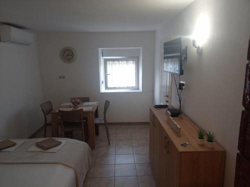 ein Hotelzimmer mit einem Bett und einem Tisch sowie einem Zimmer in der Unterkunft Apartman Dardic in Herceg-Novi