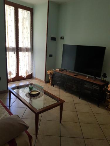 uma sala de estar com uma televisão de ecrã plano e uma mesa de centro em B&B Ortensia em Cava deʼ Tirreni