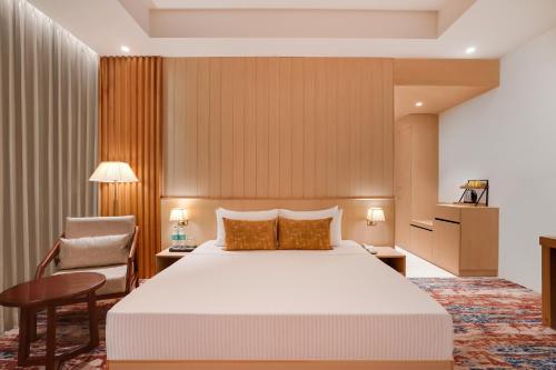 a hotel room with a bed and a chair at Lemon Tree Hotel, Haridwar in Haridwār