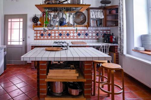 cocina con fregadero y encimera con taburetes en Alter Pfarrhof Rambow Wohnung 1, 