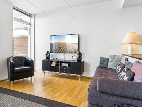 een woonkamer met een bank en een televisie bij Apartment Kimi - 100m from the sea in Western Jutland by Interhome in Havneby