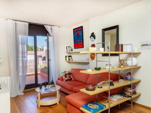 a living room with a red couch and a mirror at Apartment Gràcia- Parc Güell by Interhome in Barcelona