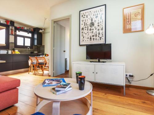 a living room with a table and a tv at Apartment Gràcia- Parc Güell by Interhome in Barcelona