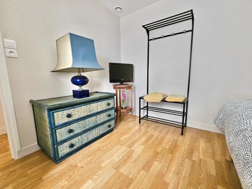 a bedroom with a dresser with a lamp on it at les chambres d'hôtes la Guiberdière in Castilly