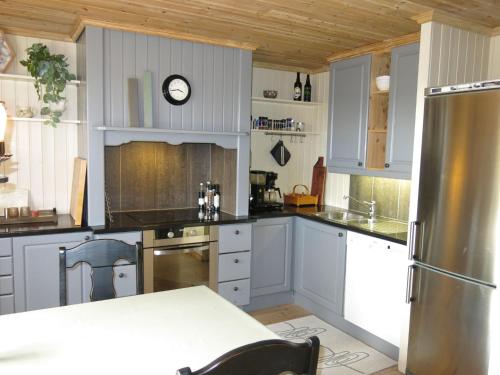 FossdalにあるHoliday Home Friabu - SOW143 by Interhomeの白いキャビネットと壁掛け時計付きのキッチン