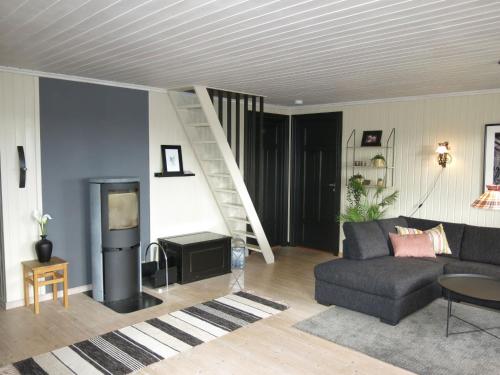 een woonkamer met een bank en een trap bij Holiday Home Friabu - SOW143 by Interhome in Fossdal