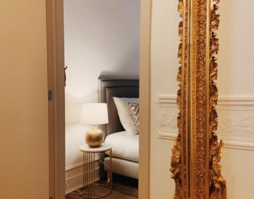 a mirror in front of a bedroom with a bed at La Lys Rooms & Suites in Ghent