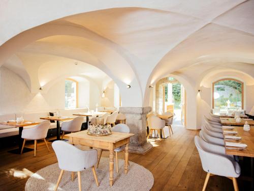 un restaurante con paredes blancas, mesas y sillas en Apartment Theo by Interhome en Stams