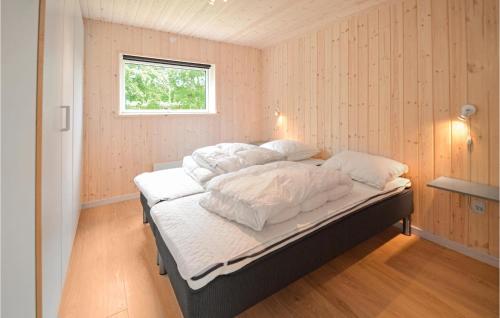a bedroom with a bed with white sheets and a window at Holiday Home Hjerm Gh-1983 in Hjerm