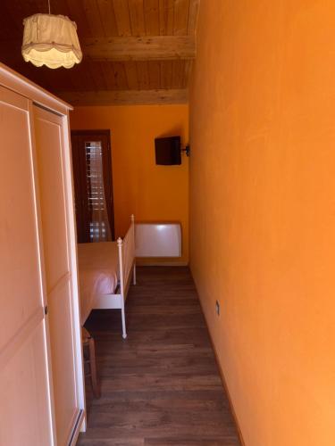 a hallway with a room with a bed and yellow walls at Lo Scoiattolo Country House in Montorio al Vomano